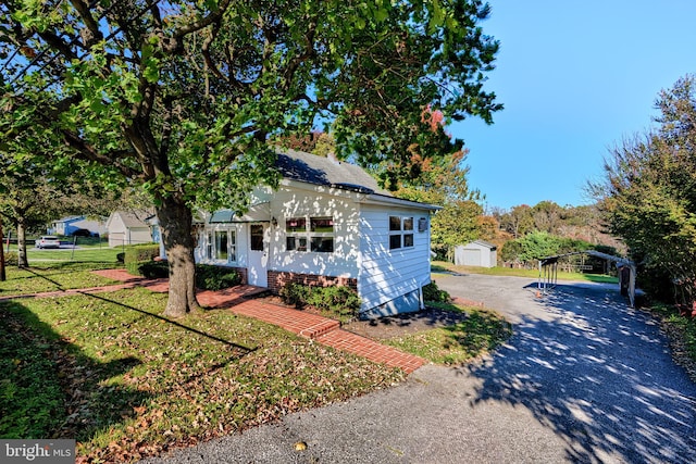 view of front of property with a front yard and a storage unit