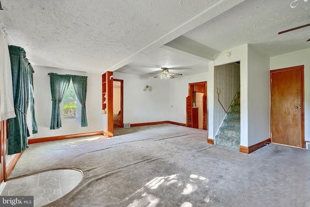 carpeted spare room with ceiling fan and a textured ceiling