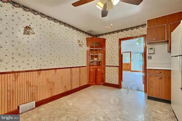 spare room featuring wooden walls and ceiling fan