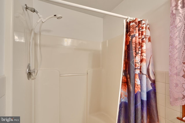 bathroom with tile walls and curtained shower