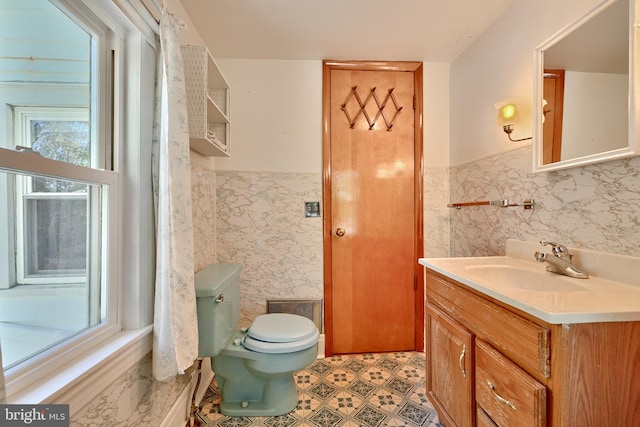 bathroom with tile walls, vanity, and toilet