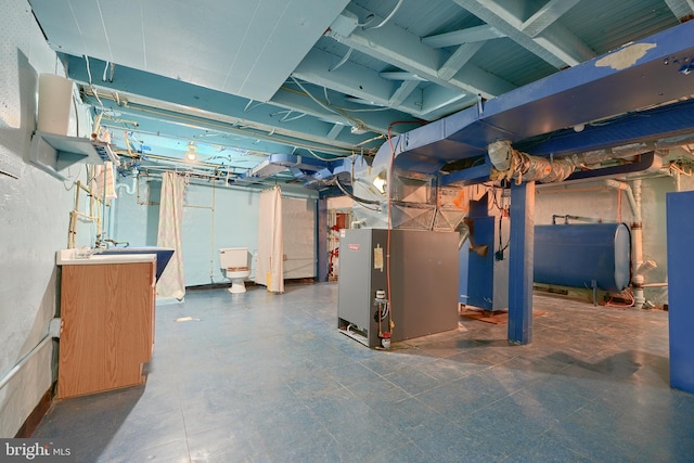 basement featuring sink and heating unit