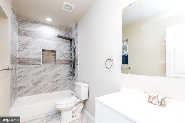 full bathroom featuring vanity, tiled shower / bath combo, and toilet