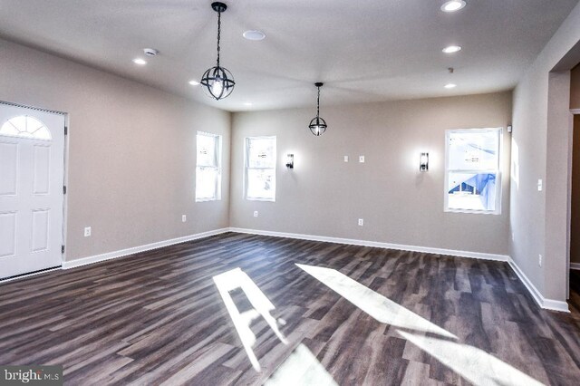 interior space with dark wood-type flooring and a chandelier