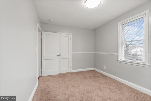 unfurnished bedroom featuring light colored carpet and a closet