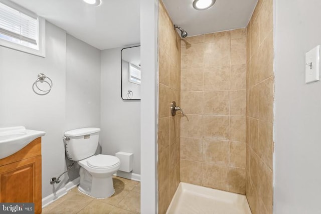 bathroom with vanity, a tile shower, tile patterned floors, and toilet