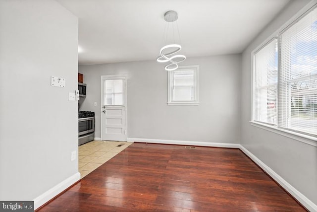 unfurnished dining area featuring hardwood / wood-style flooring and plenty of natural light