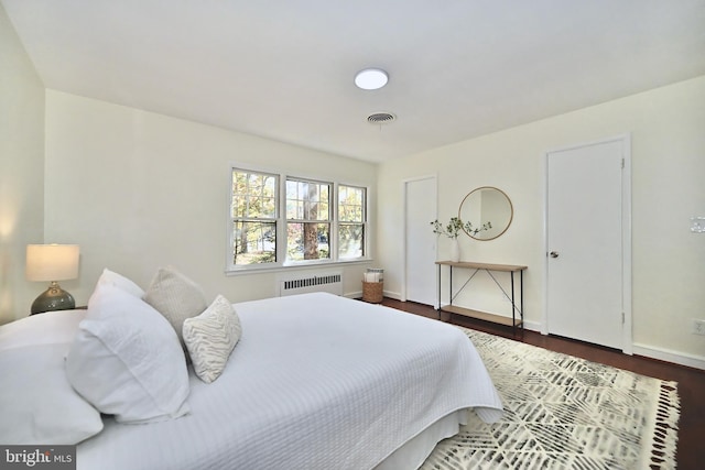 bedroom with radiator and dark hardwood / wood-style flooring