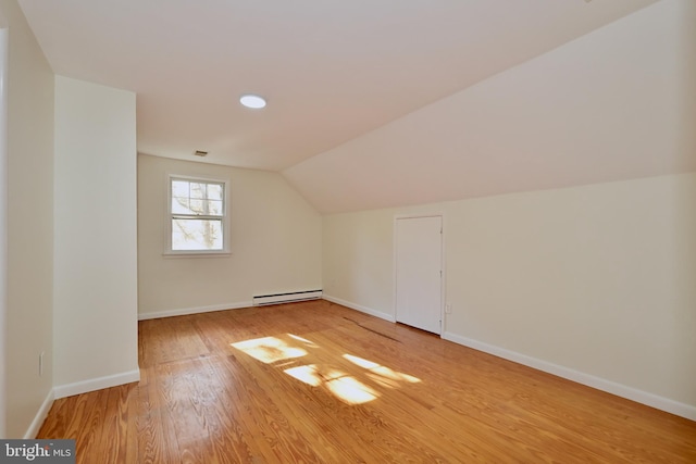 bonus room featuring lofted ceiling, a baseboard heating unit, and hardwood / wood-style flooring