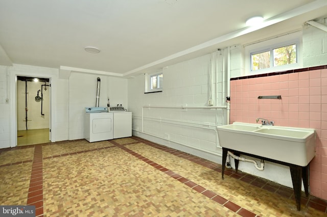 interior space with vanity, tile walls, and separate washer and dryer