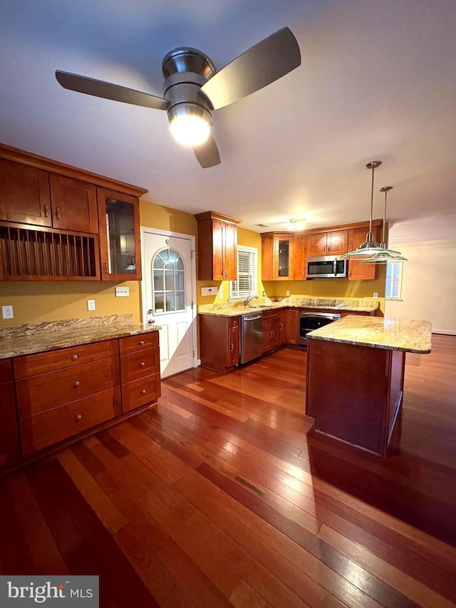 kitchen with a kitchen island, stainless steel appliances, dark hardwood / wood-style floors, and hanging light fixtures