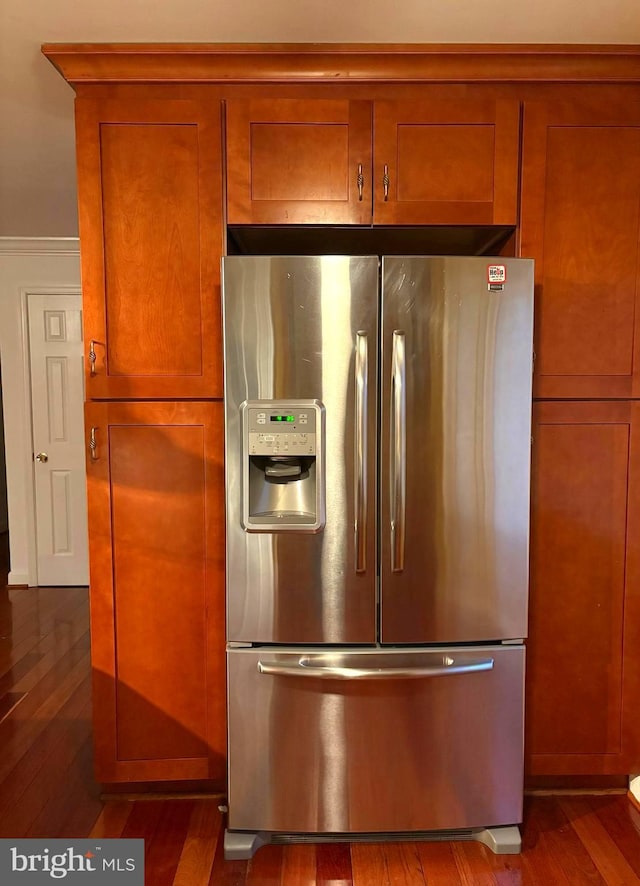 room details featuring dark wood-type flooring and stainless steel fridge