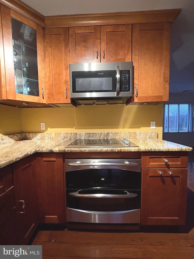 kitchen with appliances with stainless steel finishes and light stone counters