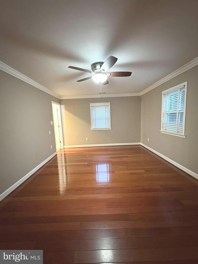 spare room featuring crown molding, dark wood-type flooring, and ceiling fan