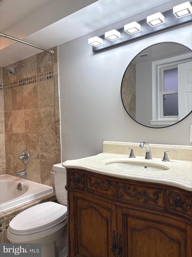 full bathroom with vanity, toilet, and tiled shower / bath combo