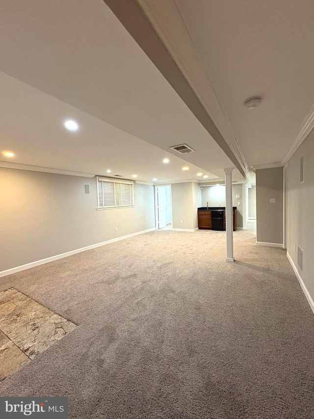 basement with ornamental molding and carpet