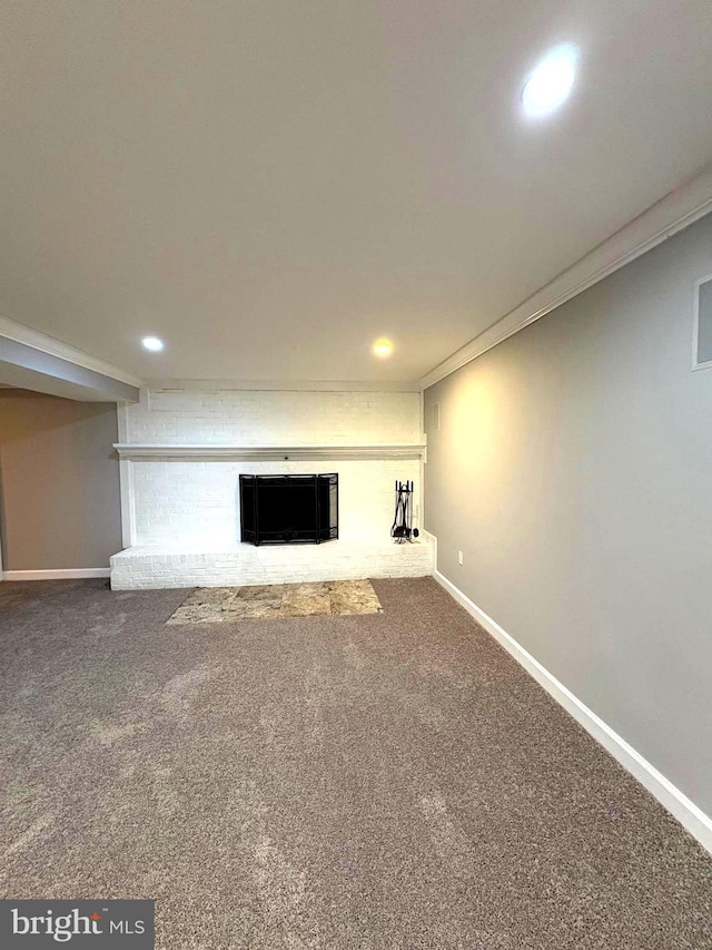 basement featuring crown molding, carpet floors, and a fireplace