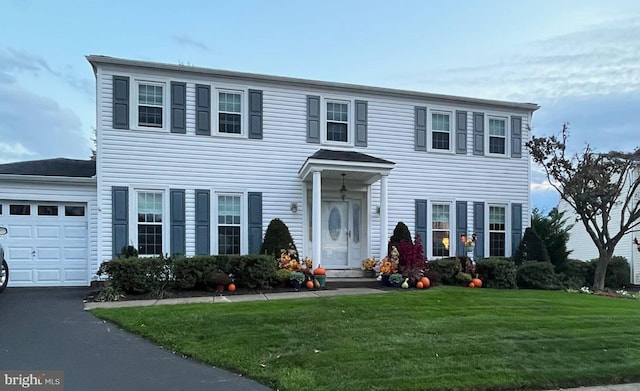 colonial house featuring a garage and a front yard