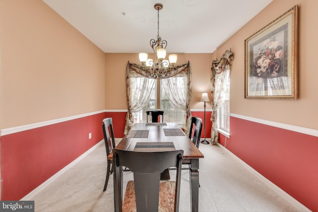 dining room featuring carpet flooring and an inviting chandelier