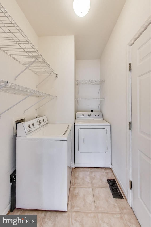 laundry area featuring light tile patterned floors and washing machine and clothes dryer