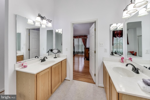 bathroom featuring hardwood / wood-style floors, vanity, and a notable chandelier