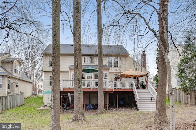 rear view of house featuring a gazebo and a wooden deck