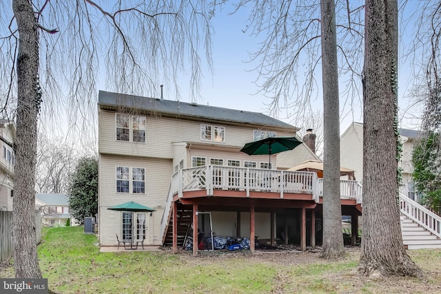 back of property featuring a deck and a yard