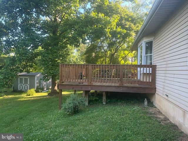 deck with a storage shed and a yard