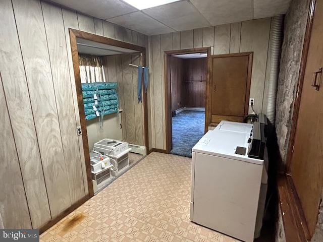 washroom with washer / dryer, light colored carpet, wooden walls, and a baseboard radiator