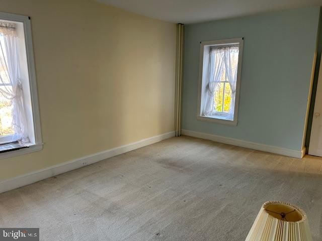 carpeted empty room featuring a wealth of natural light