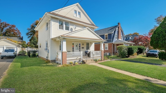 view of front property featuring a garage, covered porch, an outdoor structure, and a front yard