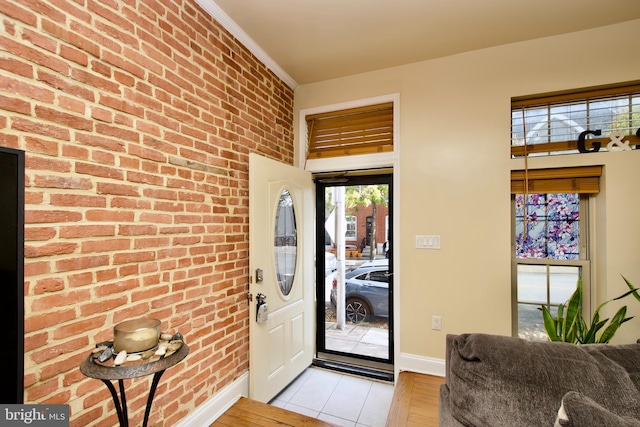 entryway featuring light hardwood / wood-style floors and brick wall