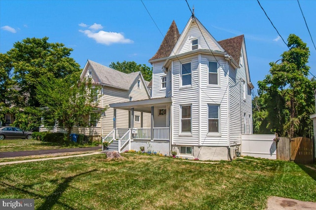 victorian house featuring a porch and a front lawn