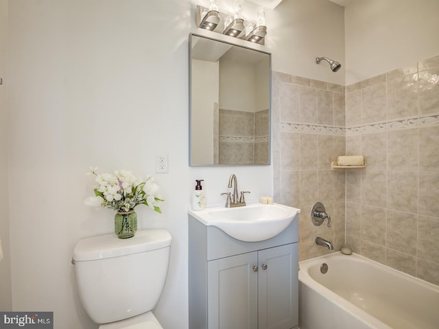 full bathroom featuring vanity, tiled shower / bath combo, and toilet