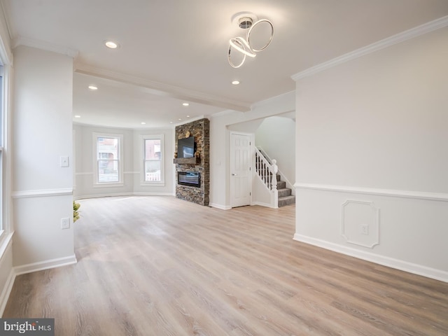 unfurnished living room featuring crown molding, a fireplace, and light hardwood / wood-style floors