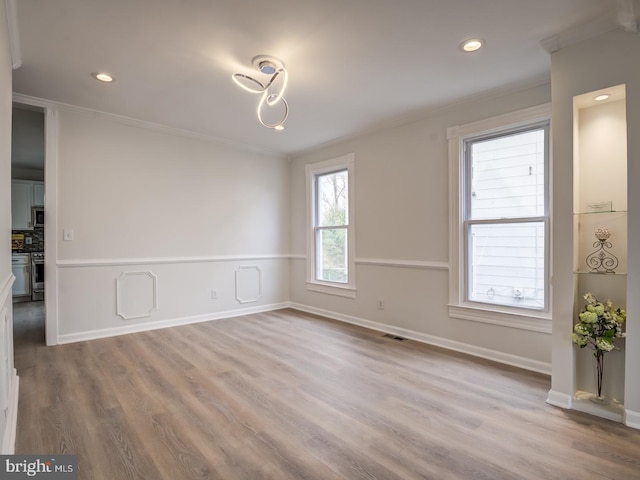 unfurnished room with light hardwood / wood-style flooring and crown molding