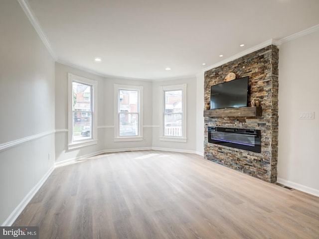 unfurnished living room with a stone fireplace, crown molding, and light hardwood / wood-style flooring