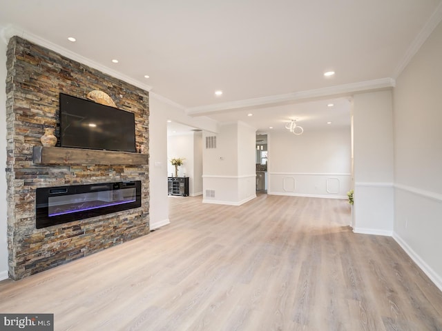 unfurnished living room with crown molding, a fireplace, and light wood-type flooring