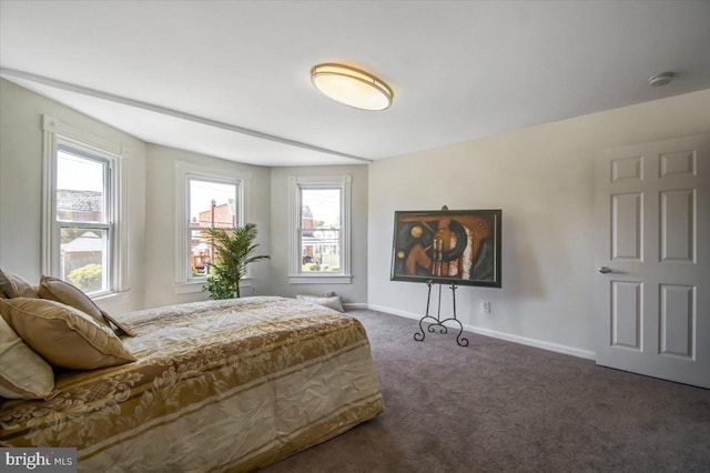 bedroom with dark carpet and multiple windows