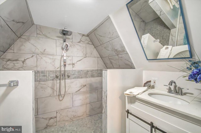 bathroom featuring a tile shower and vanity