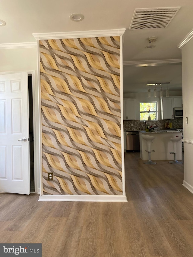 516 Harwood Ave, Baltimore, MD 21212 - detailed view of stainless steel appliances, ornamental molding, decorative backsplash, wood finished floors, and baseboards