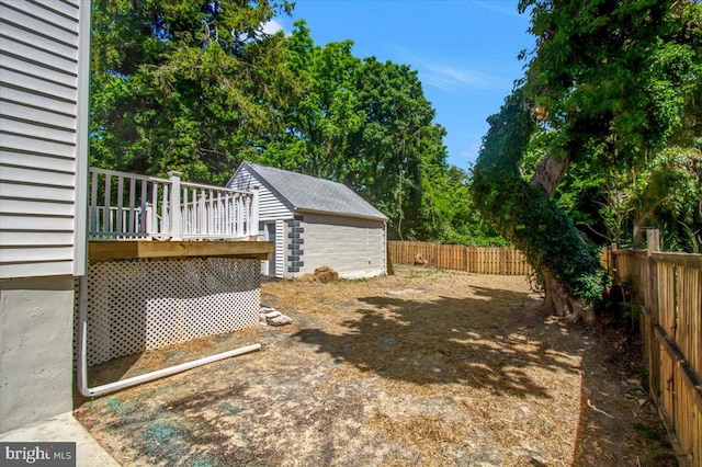 view of yard with a wooden deck and an outbuilding