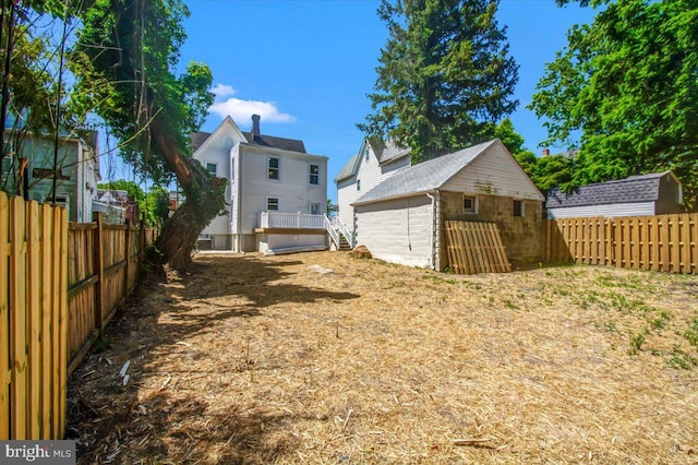 view of yard with a wooden deck and an outbuilding