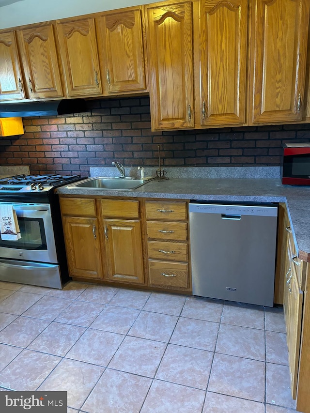 kitchen with stainless steel appliances, decorative backsplash, and light tile patterned flooring