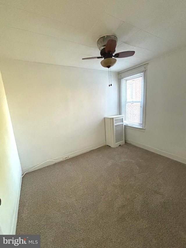 spare room with ceiling fan and carpet