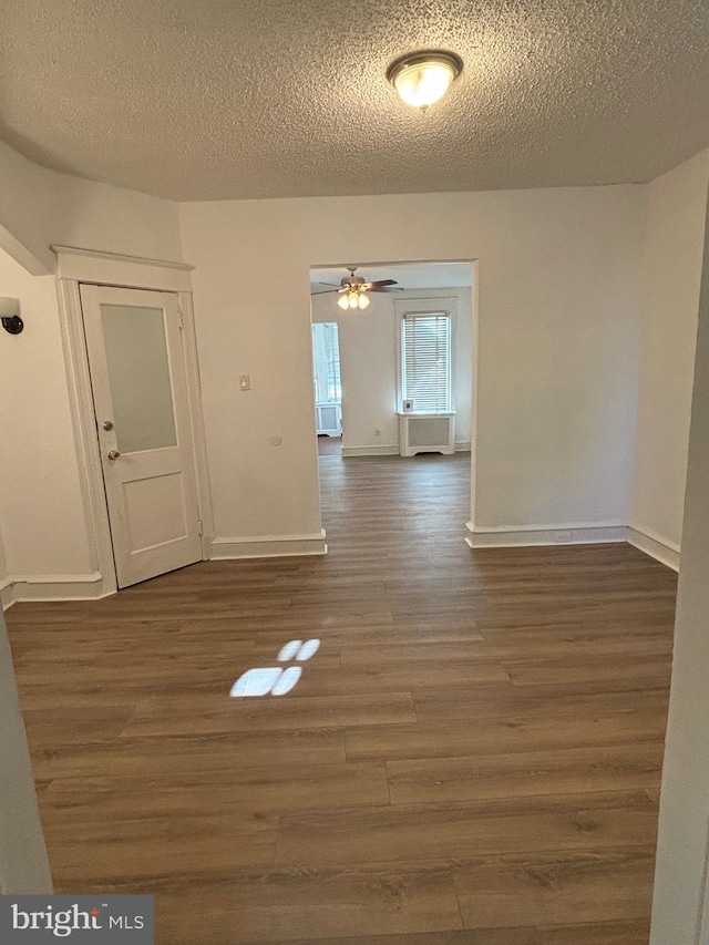 unfurnished room with dark wood-type flooring, ceiling fan, and a textured ceiling