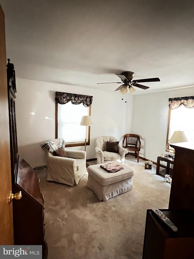 carpeted living room with ceiling fan