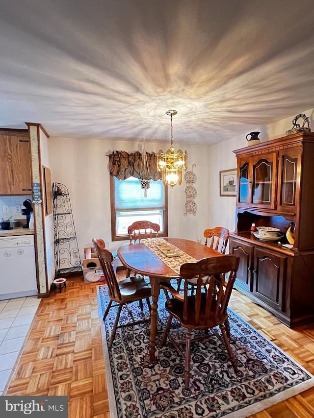 dining area with a chandelier and light parquet flooring