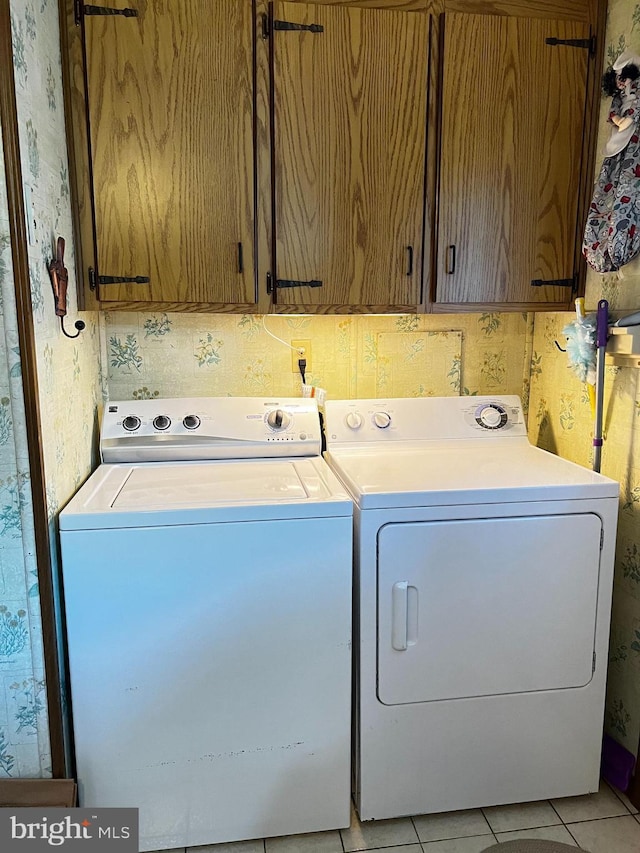 5216 Huron St, College Park, MD 20740 - laundry area featuring cabinet space, washing machine and clothes dryer, wallpapered walls, and light tile patterned flooring