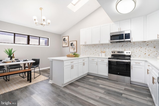 kitchen with white cabinetry, dark wood-type flooring, stainless steel appliances, and decorative light fixtures